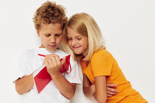 メモ帳の色の背景が変更されていないカラフルなTシャツで楽しい子供たち