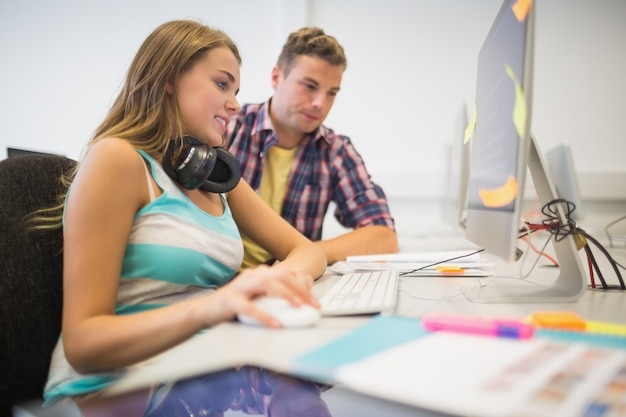 Cheerful classmates doing an assignment together in the computer room