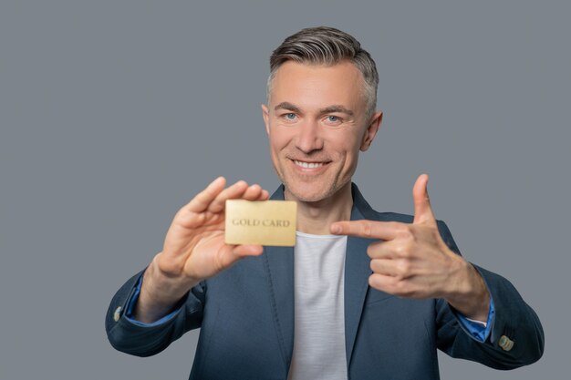 Cheerful confident man pointing at credit card