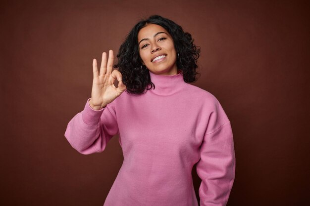 Cheerful and confident showing ok gesture