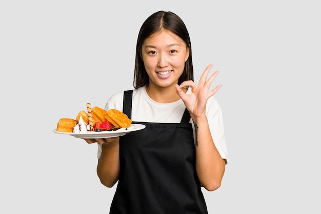 Cheerful and confident showing ok gesture