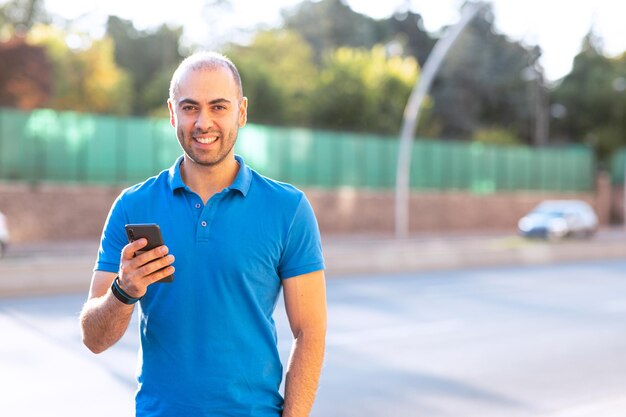 Cheerful and confident young man checking his emails while posing to camera Includes copy and text space