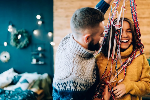 Cheerful couple celebrating special occasion with party streamer