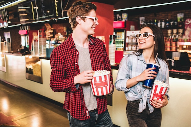 Cheerful couple in glasses are looking to each other and smiling