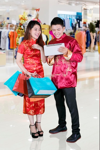 Cheerful couple is shopping online with tablet