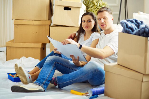 Cheerful couple looking at construction house plan