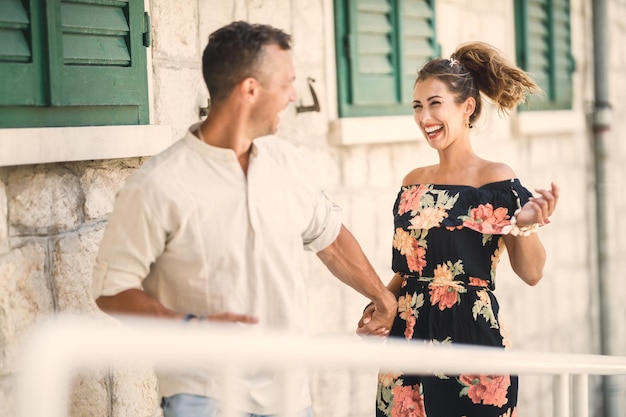 Cheerful couple in love having fun and dancing down the Mediterranean city while enjoying summer vacation.