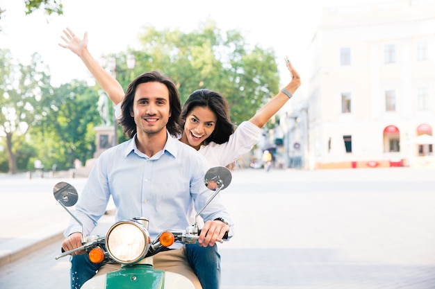 Cheerful couple riding on a scooter