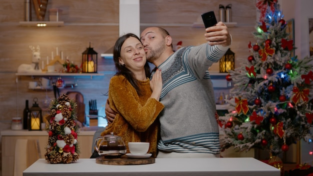 Cheerful couple taking pictures on christmas eve