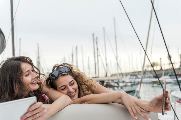 Foto una coppia allegra che si fa un selfie sulla barca.