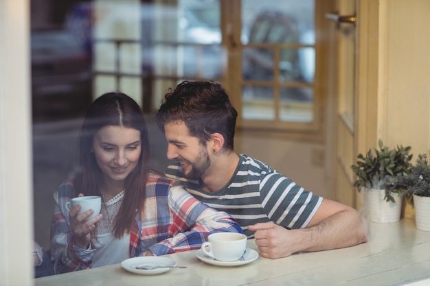 Cheerful couple talking at coffee shop