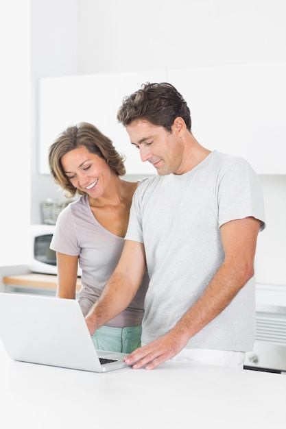 Cheerful couple using laptop