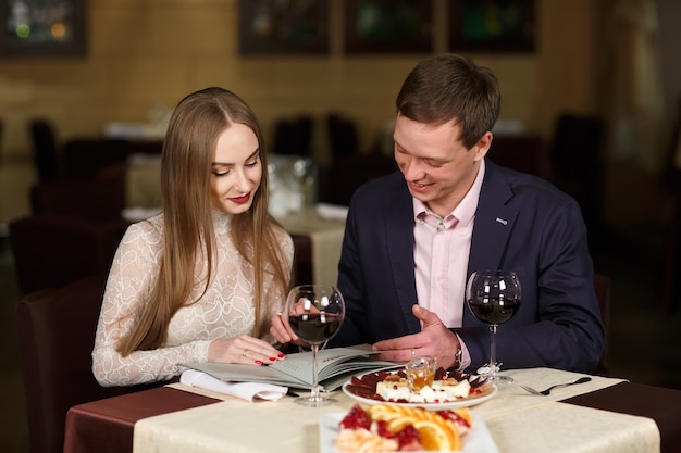 Cheerful couple with menu in a restaurant.