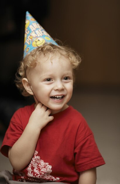 Foto un ragazzo carino e allegro che indossa un cappello da festa.