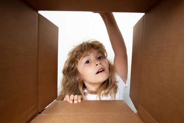 Cheerful cute child opening a present cardboard boxes parcels delivery service concept kid opening p