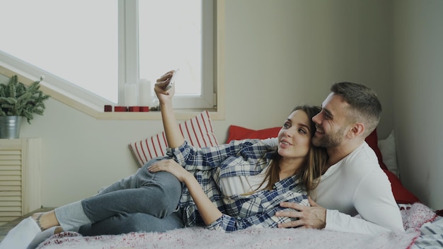 Cheerful cute and loving couple talking video call using smartphone camera