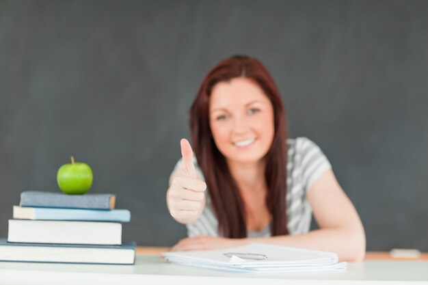 Cheerful cute student with the thumb up