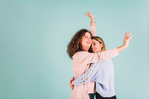 Cheerful daughter hugging mother