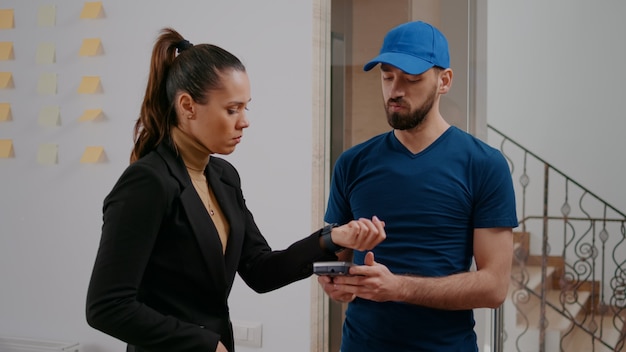 Cheerful delivery guy bringing takeaway food meal in startup company office during lunchtime