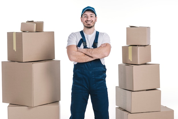 Photo cheerful deliveryman between heaps of parcels