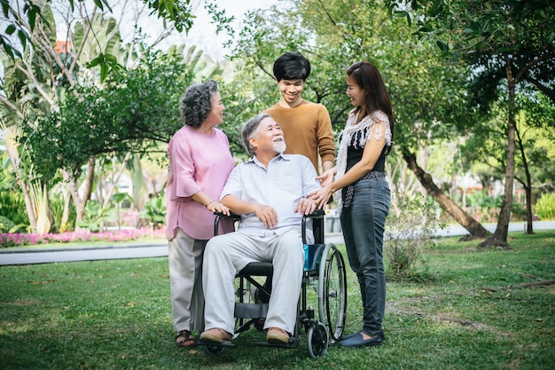 cheerful disabled grandfather in wheelchair welcoming his happy Family