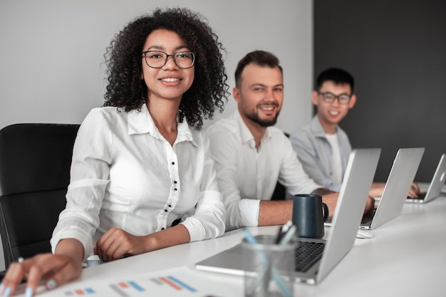 Cheerful diverse colleagues sitting at table