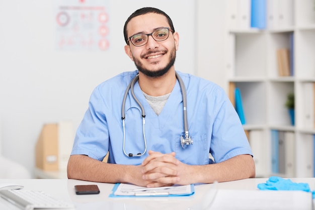 Cheerful Doctor Posing at Desk