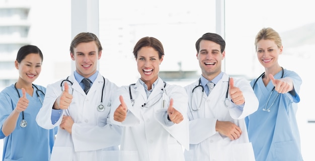 Cheerful doctors gesturing thumbs up at hospital