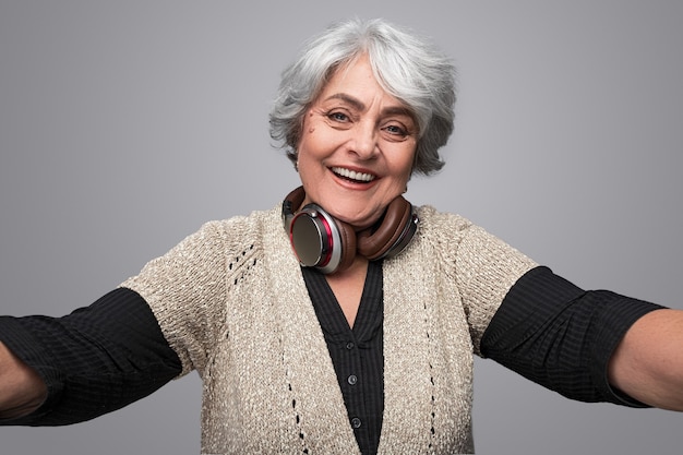 Photo cheerful elderly lady taking selfie