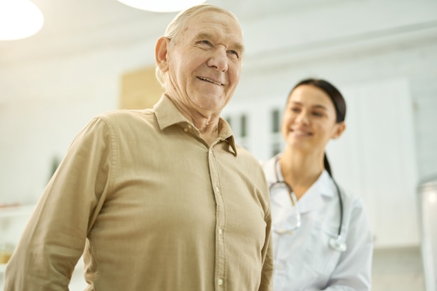 Cheerful elderly man being examined by a medical worker