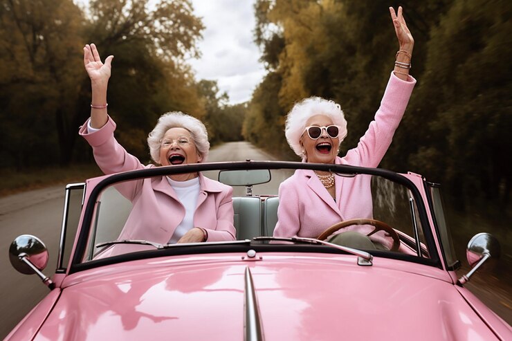 Photo cheerful elderly women good mood waving hands ride in convertible car outdoor travel
