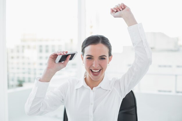 Cheerful elegant businesswoman cheering at office