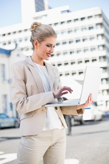 Cheerful elegant businesswoman working on laptop