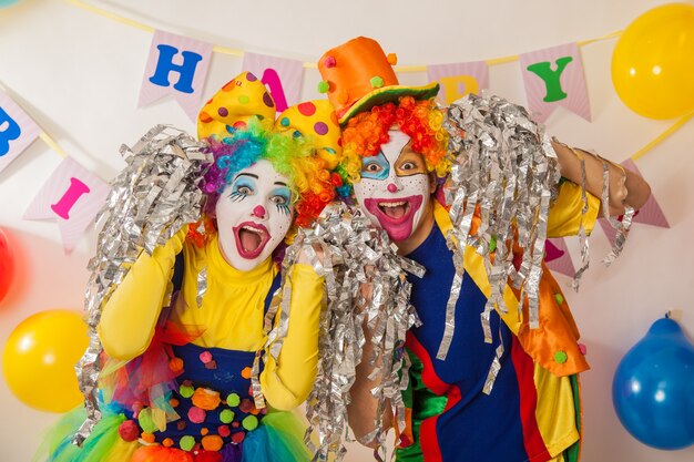 Cheerful emotional clowns at the party with paper disco