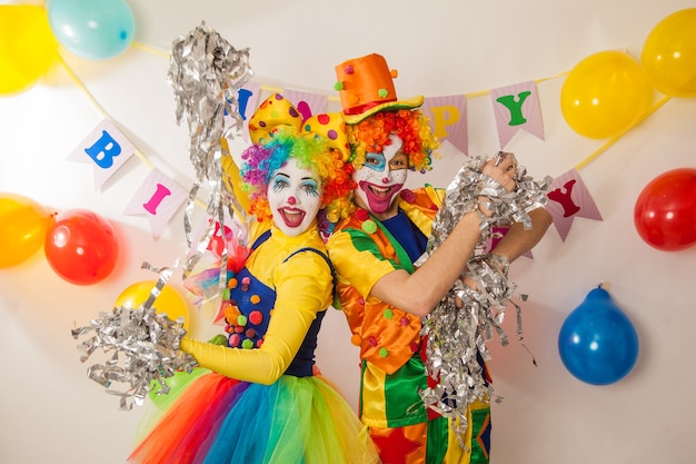 Cheerful emotional clowns at the party with paper disco