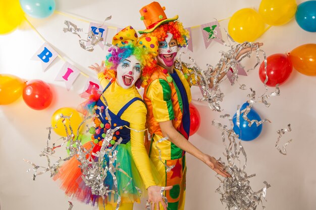 Cheerful emotional clowns at the party with paper disco