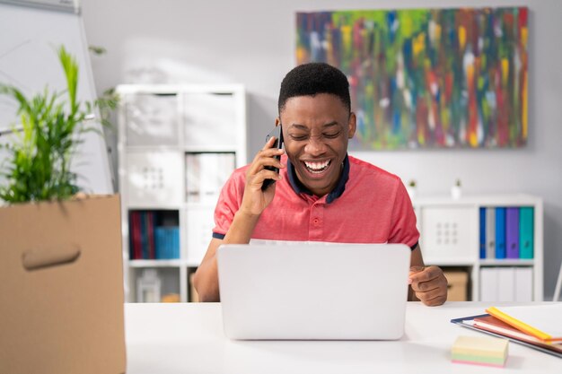 Cheerful employee fulfills work duties sits in the office in front of the laptop screen