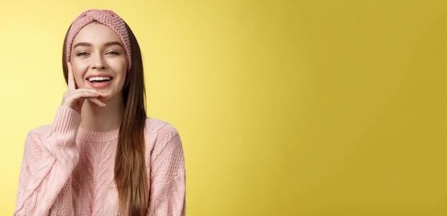 Photo cheerful entertained young attractive european woman in knitted pink headband sweater touching                                person