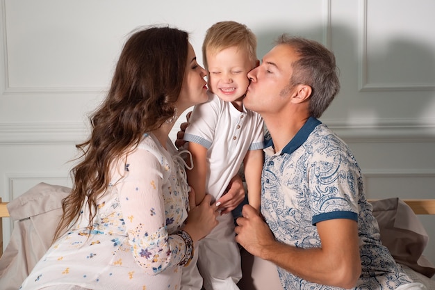 自宅の居間で息子と遊ぶ元気な妊婦夫婦。