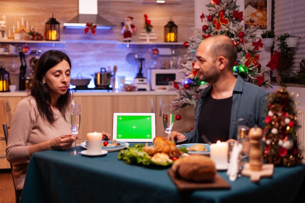 Famiglia allegra che gode della cena di natale nella cucina decorata di natale