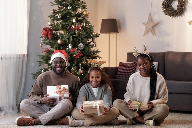 Cheerful family of father mother and daughter with christmas gifts