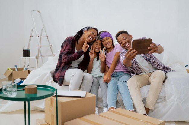 Cheerful family renovates a new apartment laughing dad takes a\
selfie with his wife and kids