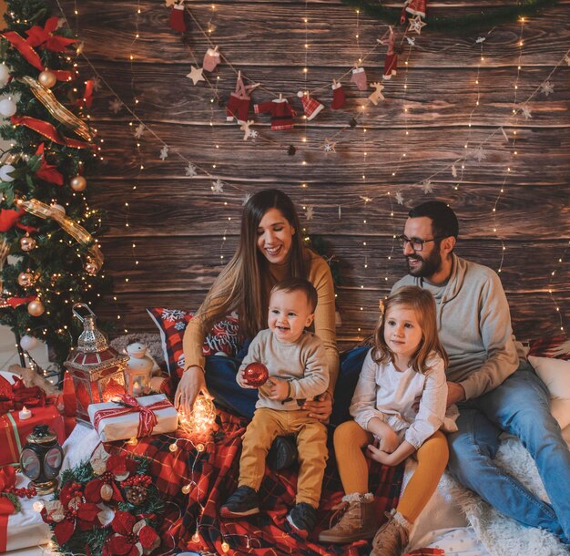 Cheerful family sitting on bed at home