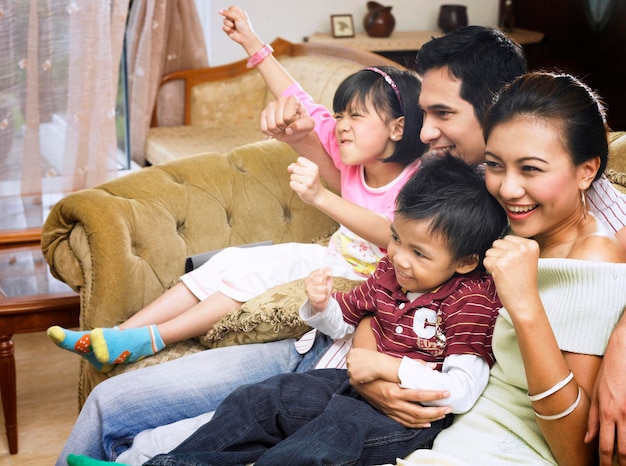 cheerful family sitting on sofa at home