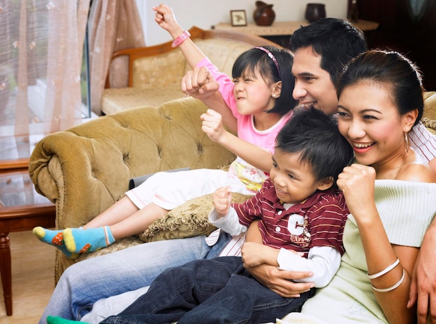 Photo cheerful family sitting on sofa at home