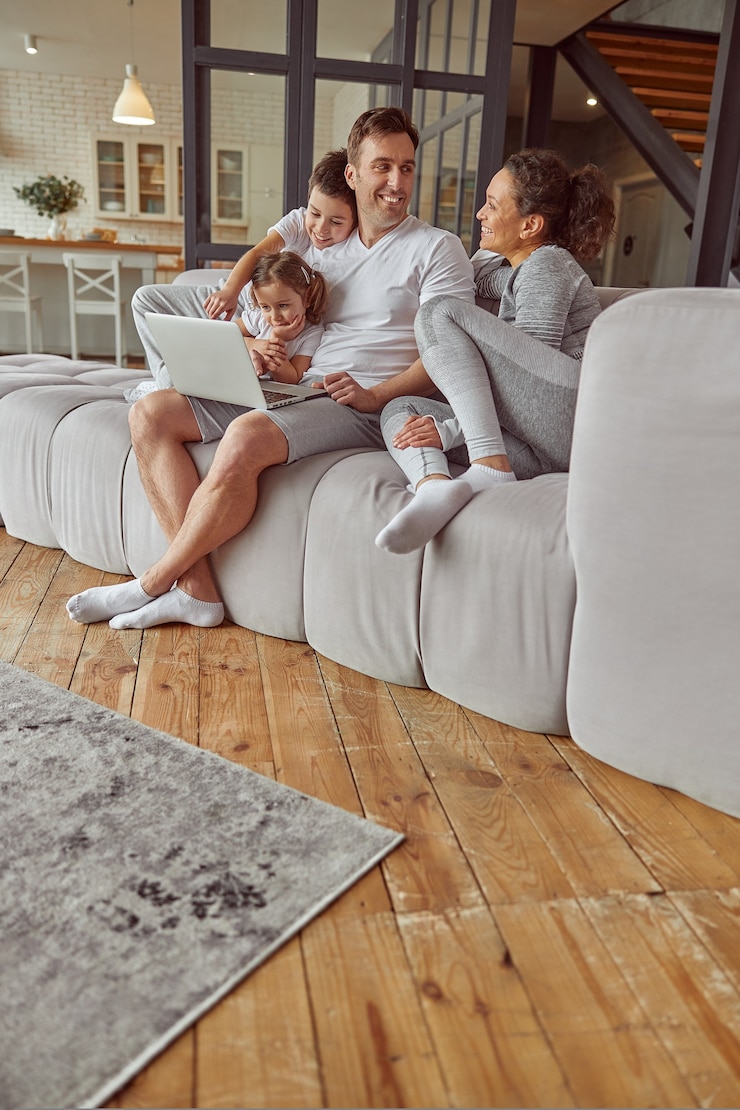 Photo cheerful family spending time with notebook at home