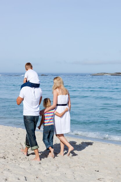 Cheerful family walking on the sand 