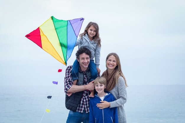 Cheerful family with kite at sea shore