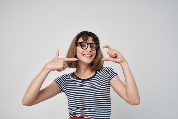Cheerful fashionable woman in striped tshirt glasses posing summer
