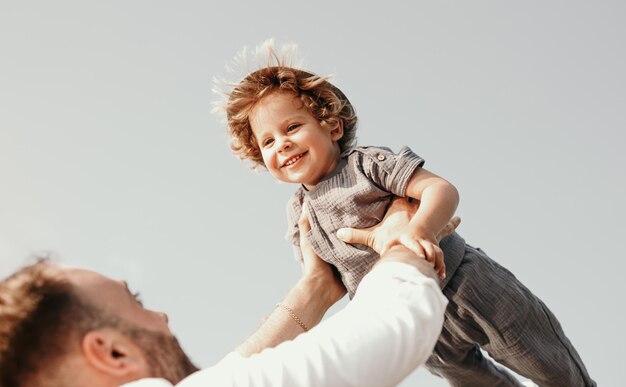 Cheerful father lifting little son